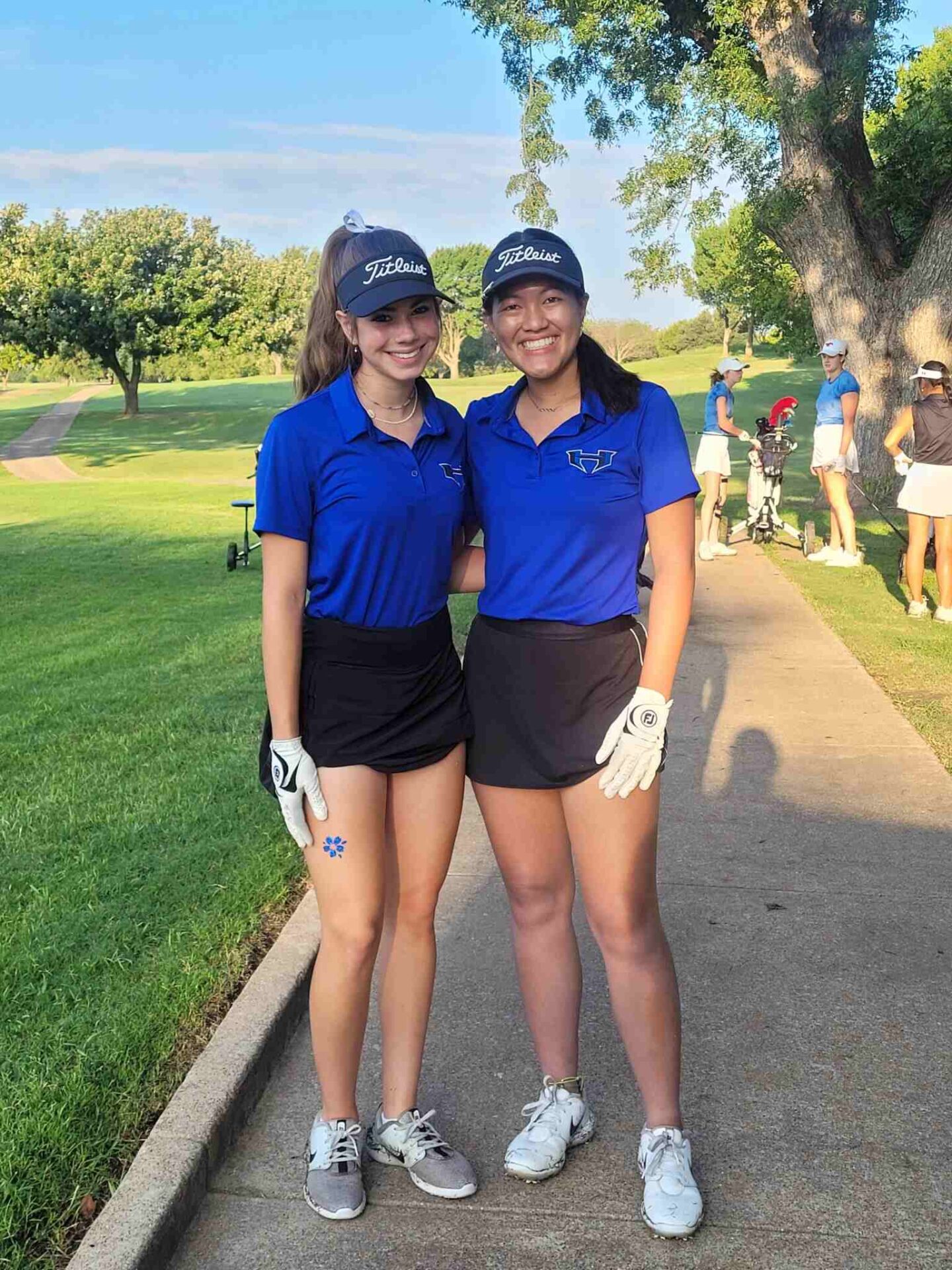 Two Women in Blue Polo Shirts and Shorts