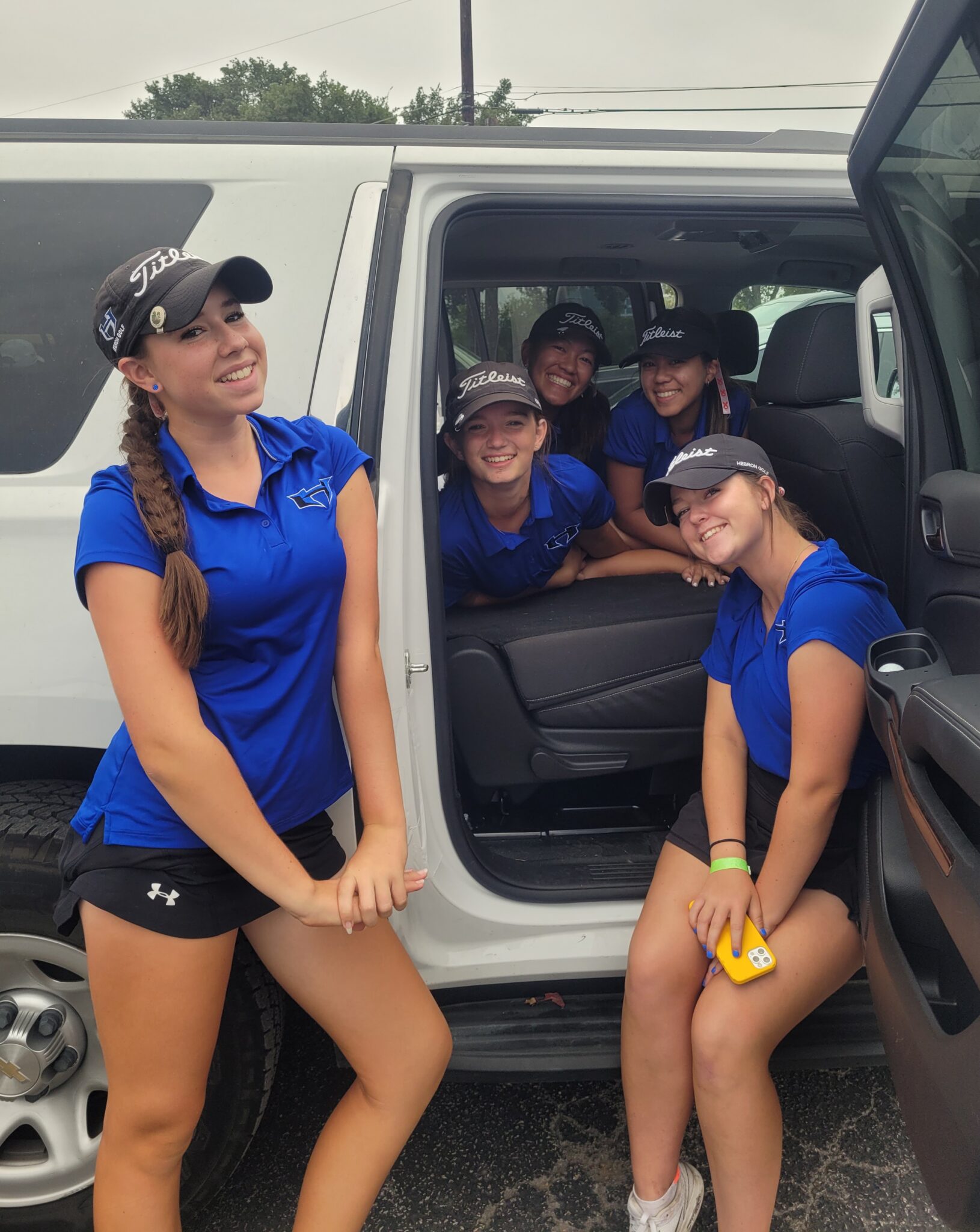 A Group of Girls in Blue and Black in a Van