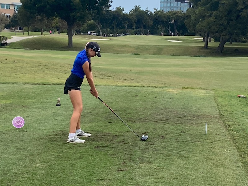 A Woman in Blue Top and Black Shorts Playing Golf