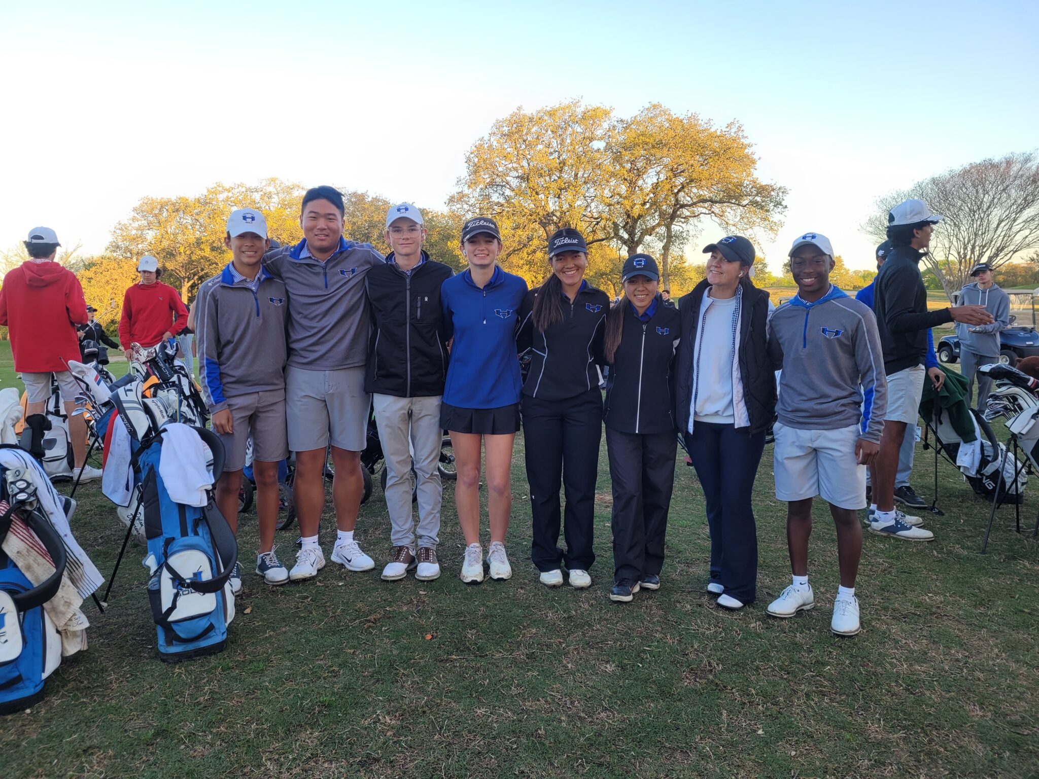 Group of girls and boys standing together with golf kit